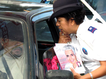 A cadet prays with a driver and distributes anti-trafficking literature