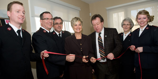 Salvation Army officers and government officials participate in a ribbon-cutting ceremony to officially open Bedford MacDonald House