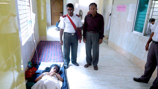 District Officer Captain Bibhudan Samaddar visits injured survivors in hospital, where medicine and beds are in short supply