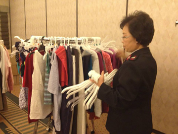 Major Ruth Lee helps straighten a rack of clothing after a group finishes picking out items