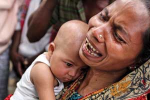 A Bangladeshi woman holds her daughter and weeps (Photo: Palash Khan, The Associated Press)