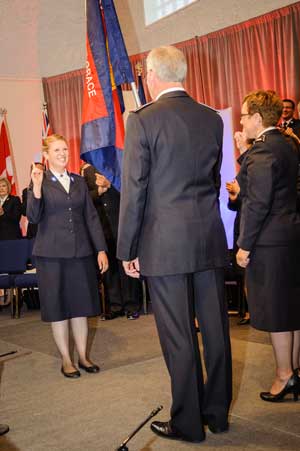 Cadet Michelle Cale salutes Commissioners Brian and Rosalie Peddle, territorial leaders