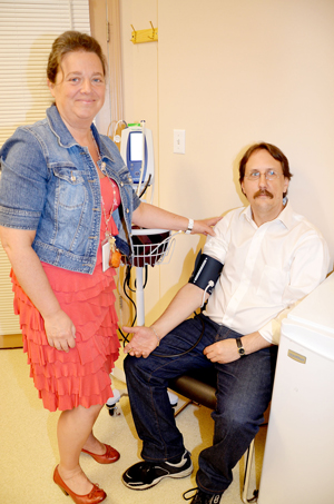 Janet Rosenfeld, the new nurse practitioner at the Caring Place, takes the blood pressure of Sean O'Connor, a regular volunteer at the facility