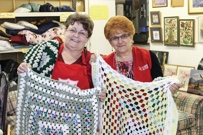 Darlene Owen (right) and Betty Stride inspect a few of the hundreds of lap blankets that will be handed out this Christmas