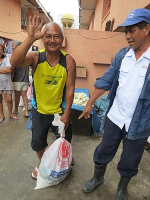 A Salvation Army officer hands out essential supplies in The Philippines