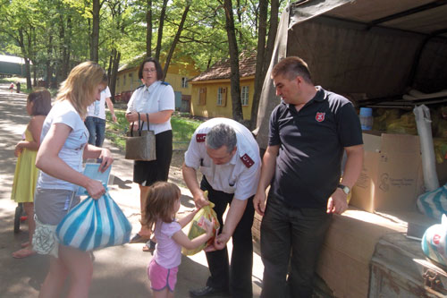 Tamara Mirgorodskaya, director of Kharkiv Social Centre; Cpt Yuri Pomytkin; and Cpt Vladimir Korenivsky, CO, Kharkiv, offer food packages to families in Kharkiv