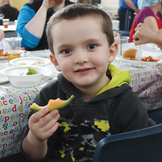 Jacob Harkin enjoys a slice of cantaloupe