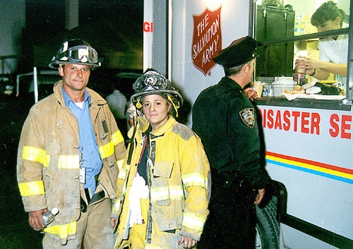 To fire fighters stand in front of a Salvation Army mobile canteen at Ground Zero following the September 11 attacks