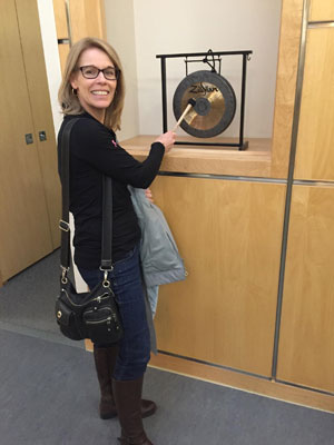 Linda Gilbert rings a gong after finishing her last treatment for breast cancer