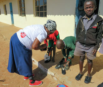 Moyo helps children try on their new shoes