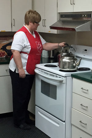 Major Pauline Randell, corps officer, Mount Pearl, prepares hot water for tea and coffee