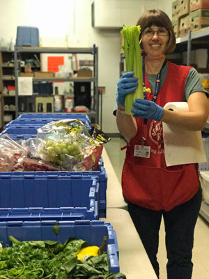A Salvation Army worker holds up fresh vegetables