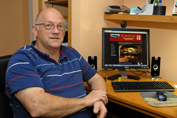 Richard Knapman, project leader and developer of TheSpiritualCafe.ca, sits at his computer