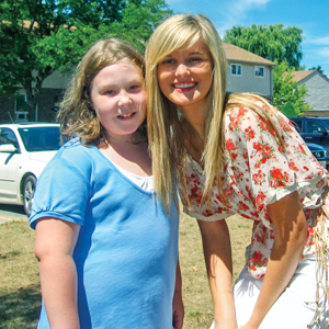 “I feel closest to God when I am helping others,” says Camp at Home staff member Sarah Burford, here with a child in London, Ont.