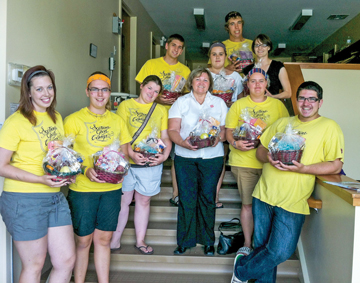 Members of the summer mission team, with Major Judy Folkins, CO, Sussex CC, prepare gift baskets for shut-ins in Sussex, N.B.