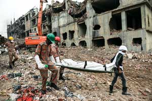 Rescuers carry a body retrieved from the rubble of the Rana Plaza building (Photo: Ismail Ferdous, The Associated Press)