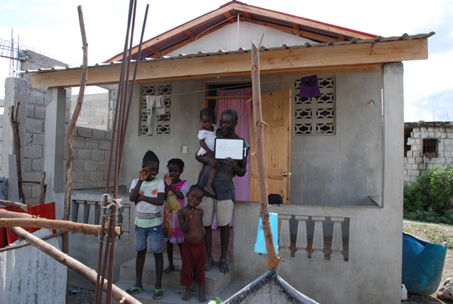 Frenel and his children n front of their new home