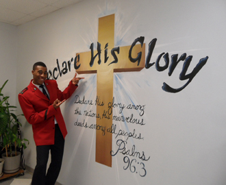 Artist Kevin Simmons proudly displays his contribution to congress celebrations, a painting of a cross with the words of Psalm 96:3