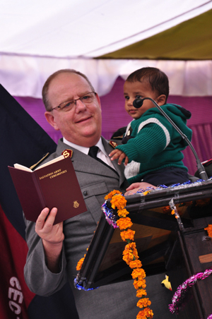 General André Cox, holding a young boy, shares a message in India Northern Territory