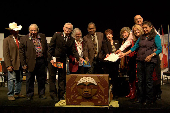 Members of the CCC delegation place a copy of “Let Us Walk Together” in the Bentwood Box