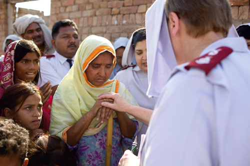 Major Gillian Brown shares a quiet moment with some townspeople. Pakistani Christians are sometimes the victims of strife and The Salvation Army provides spiritual and material aid here