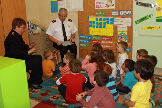 Commissioners Rosalie and Brian Peddle share a story with children at an Army daycare in Medicine Hat, Alta.