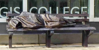 Statue of Jesus the Homeless by Canadian sculptor Timothy Schmatz, on a bench outside Regis College, Toronto