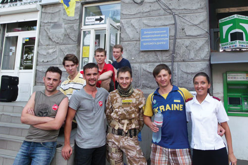 Lt Valeriya Lukina, CO, Dnepropetrovsk, and senior soldier Dmitry Rak (to her left) share a smile with Salvation Army volunteers and others at an IDP registration centre in Dnepropetrovsk