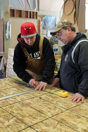 Wolf Squires measures wood with Scott Concordia