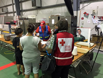 Two evacuees and a Red Cross worker receive a meal at a Salvation Army reception centre