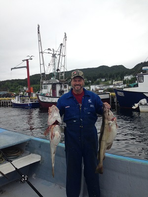 Photo of Col Lindsay Rowe holding fish on fishing boat