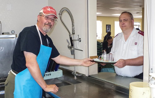 Hazen Taylor in the dish pit at the Lighthouse Centre. “Volunteering is a great way to meet the community,” he says. “It's a pleasure to serve those in need.” Captain Gordon Taylor helps out in the dining room.