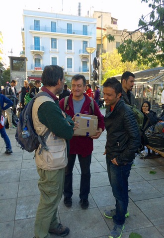 Major Haris Giannaros and Major Polis Pantelidis, regional officer for Greece, speak with a young man from Afganistan