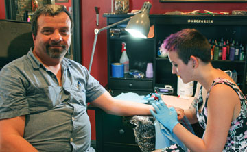 Photo of Ken Debney getting a tattoo