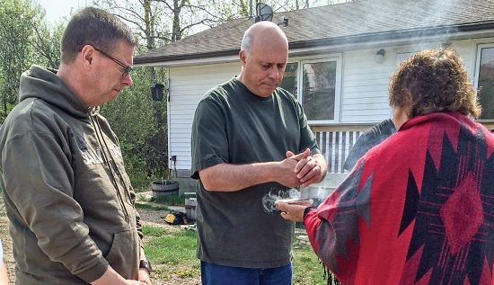 Mjr Doug Binner, corps ministries secretary, and Colonel Mark Tillsley, chief secretary, participate in a smudging ceremony led by Eileen Thomas at an Aboriginal roundtable in May