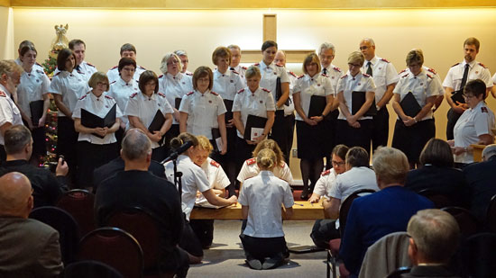 The staff songsters kneel at the mercy seat and sign their covenants