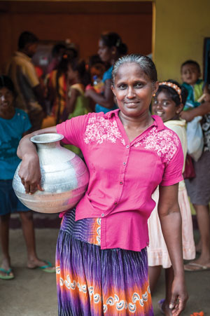 A woman brings a vessel to the new well to get safe water for her family. 