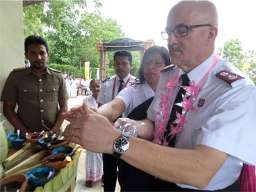 Mjr Peter McGuigan lights a candle during the traditional oil lamp ceremony