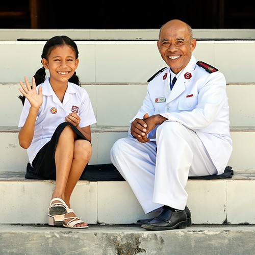 A man and a girl are seated together on steps, enjoying a moment of companionship and relaxation.