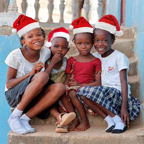 A joyful gathering of children adorned in Santa hats, embodying the spirit of Christmas with their bright smiles.