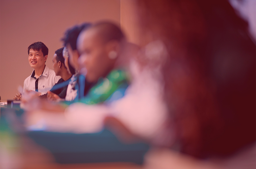 Un groupe d’apprenants adultes qui écoutent attentivement. 