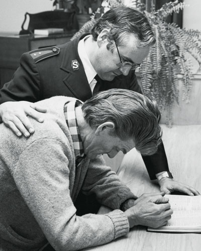 Photo of then-Captain Weldon Carr counselling a man in the chapel of the Richmond Street Rehabilitation Centre in Toronto, circa 1980