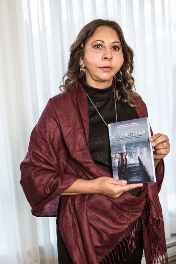 Kamal holds her book, Black and Blue Sari