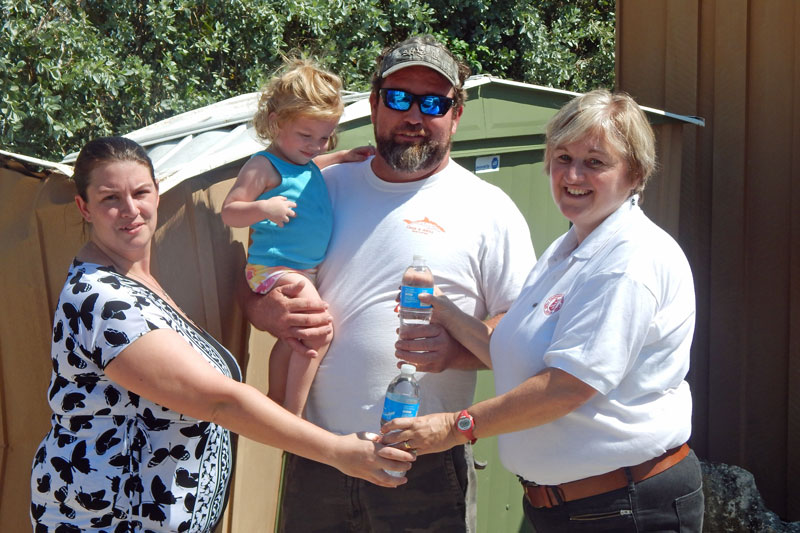 Linda Leigh hands out water to a family whose home was badly damaged by hurricane Irma