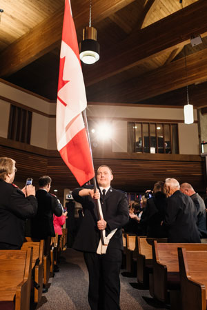 The Canadian and Salvationist flags are marched in