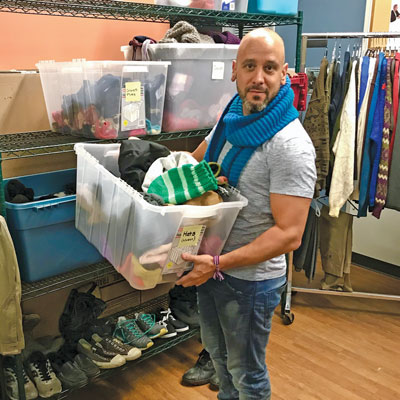 Brian Shurman organizes the clothing room at The Gateway shelter in Toronto