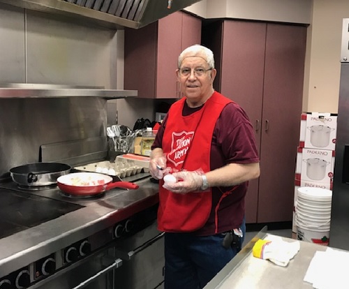 A Salvation Army worker makes food for flood victims