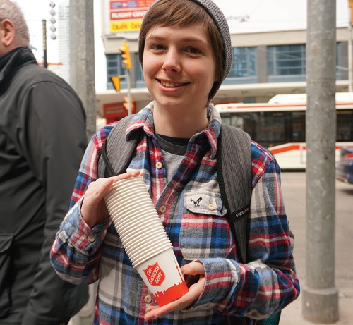 A member of the youth group distributes paper cups to those wanting coffee