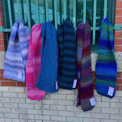 Scarves made by CommuKNITy Cares volunteers left on fences.