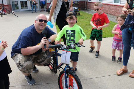 Major Corey Vincent gives a child a bicycle